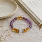 Healing crystal bracelet with amethyst and citrine resting elegantly beside an open journal for a mindful aesthetic.