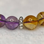 Macro shot of natural amethyst and citrine crystal beads with silver spacers, revealing the authentic gemstone textures.