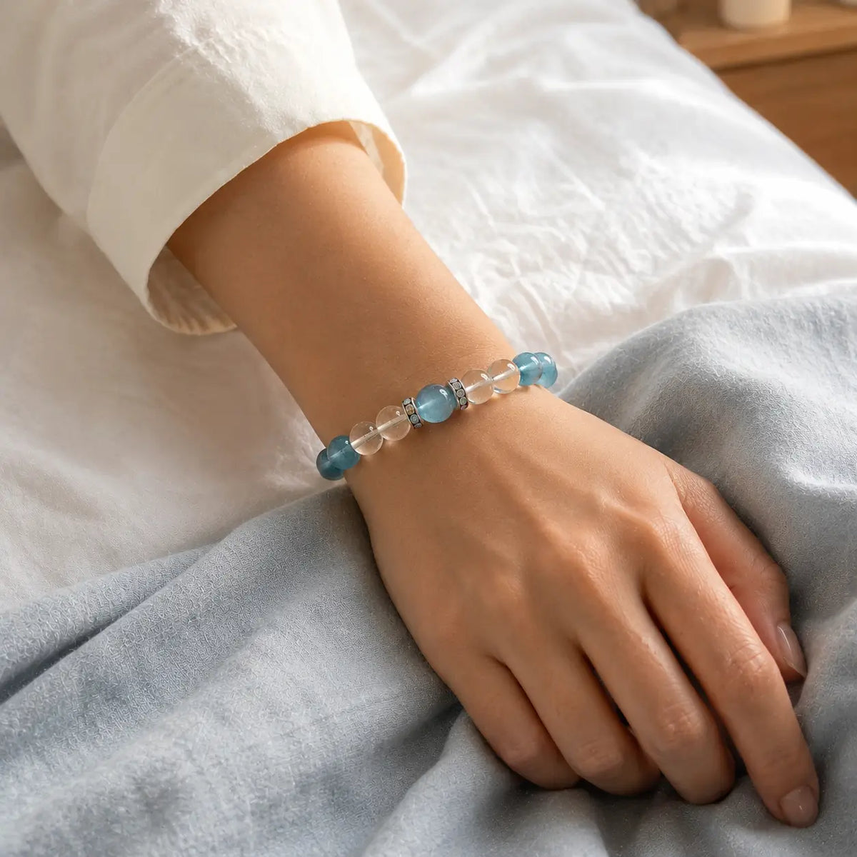 Woman wearing an aquamarine bracelet with clear quartz beads in a calm everyday setting