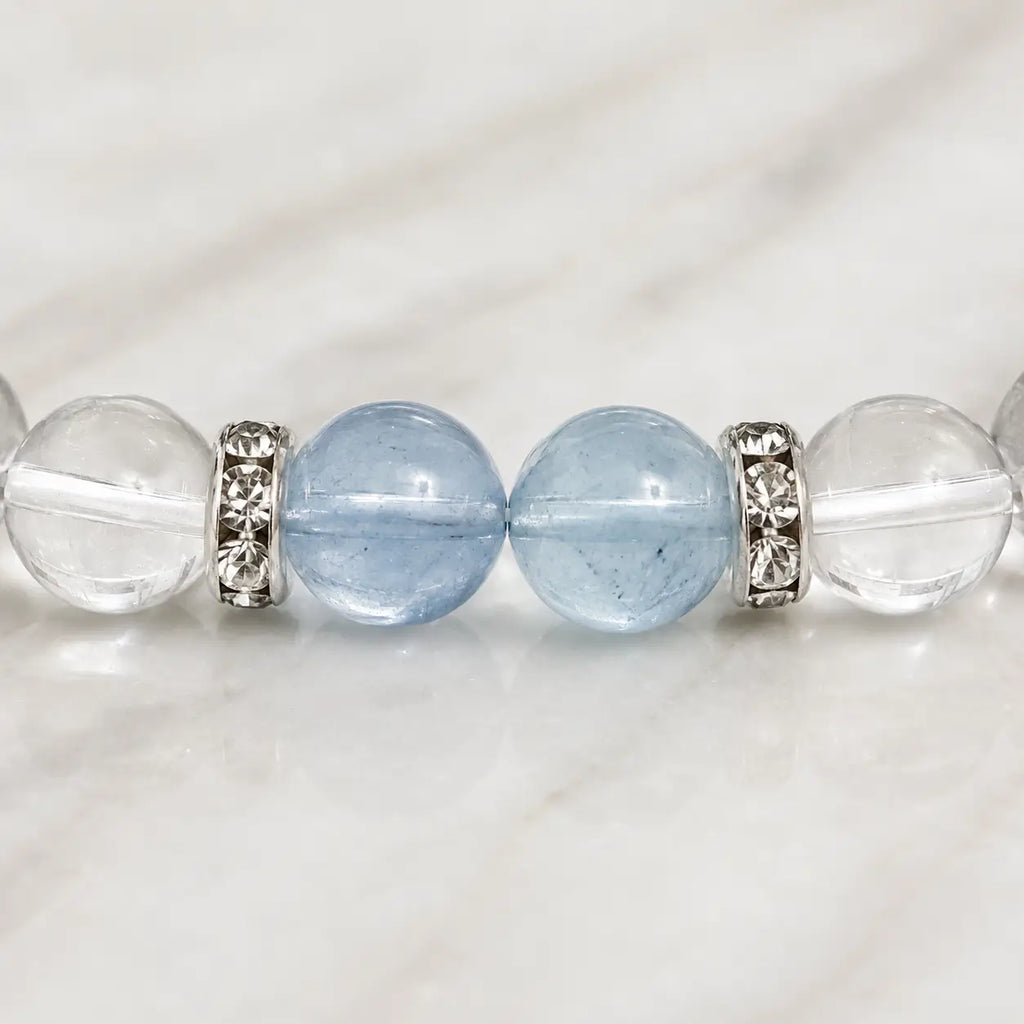 AURA Amulet macro detail of aquamarine bead and silver spacers on a clear quartz bracelet.