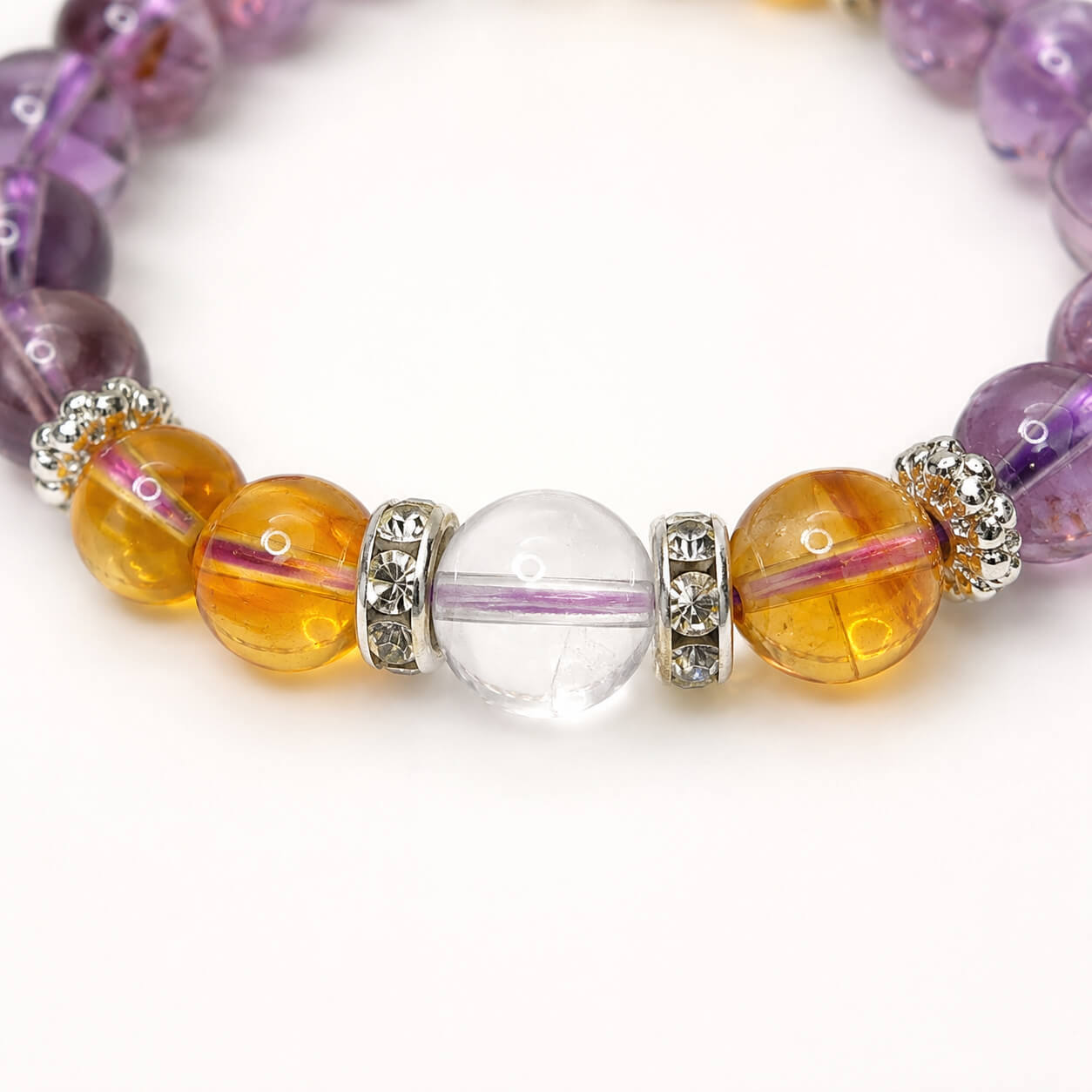Detail shot of a clear quartz and citrine bracelet featuring sparkling silver spacer beads and translucent stones.