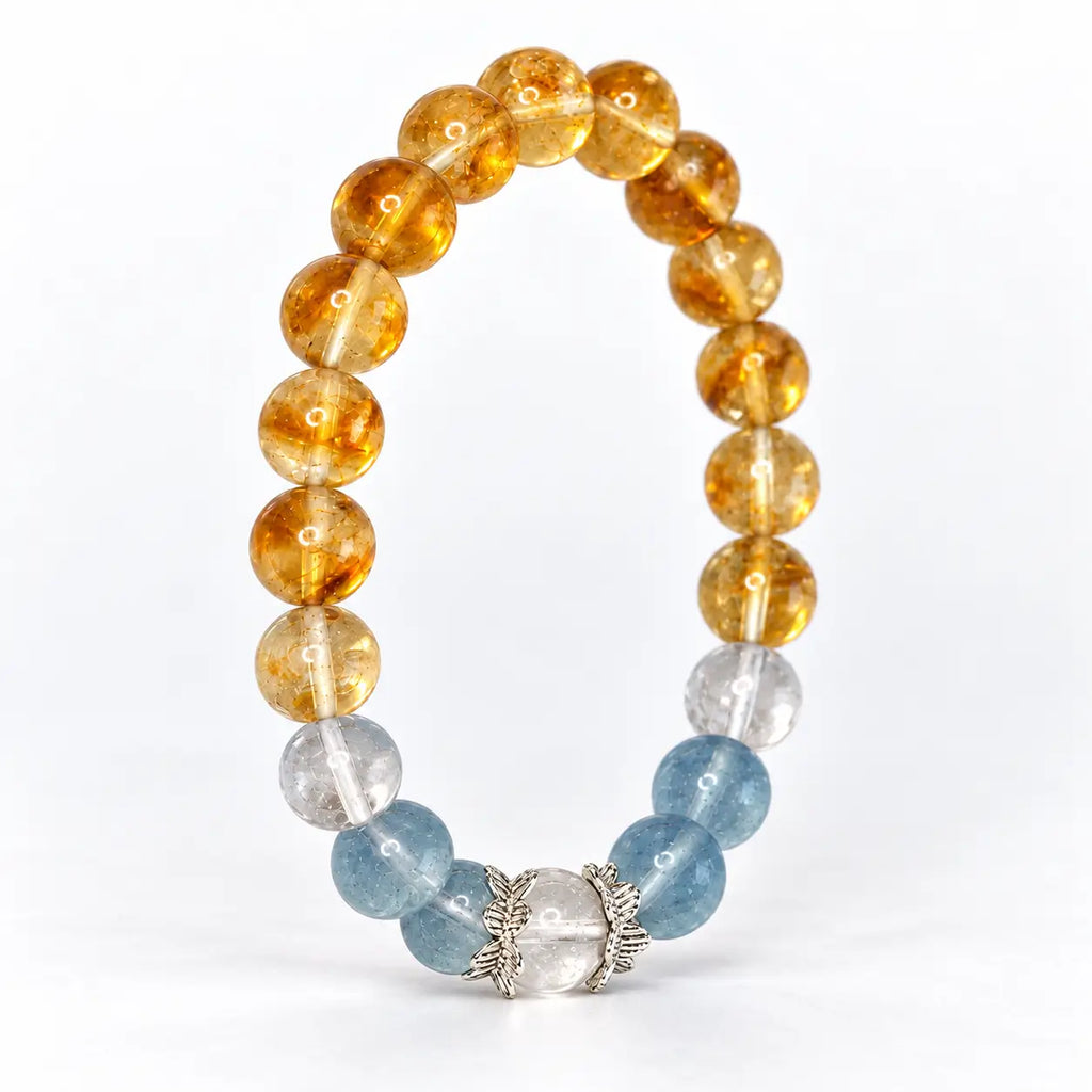 Upright citrine and aquamarine bracelet showing its oval profile and clear quartz center framed by silver-tone lotus caps.