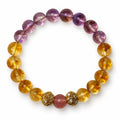 Round bracelet with yellow citrine, purple amethyst and a strawberry quartz center bead on a white background.