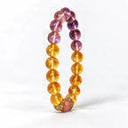 Upright citrine and amethyst bracelet showing round gemstone beads and gold-tone floral spacers.