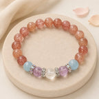 Strawberry quartz bracelet with aquamarine, amethyst and clear quartz beads on a cream stone tray