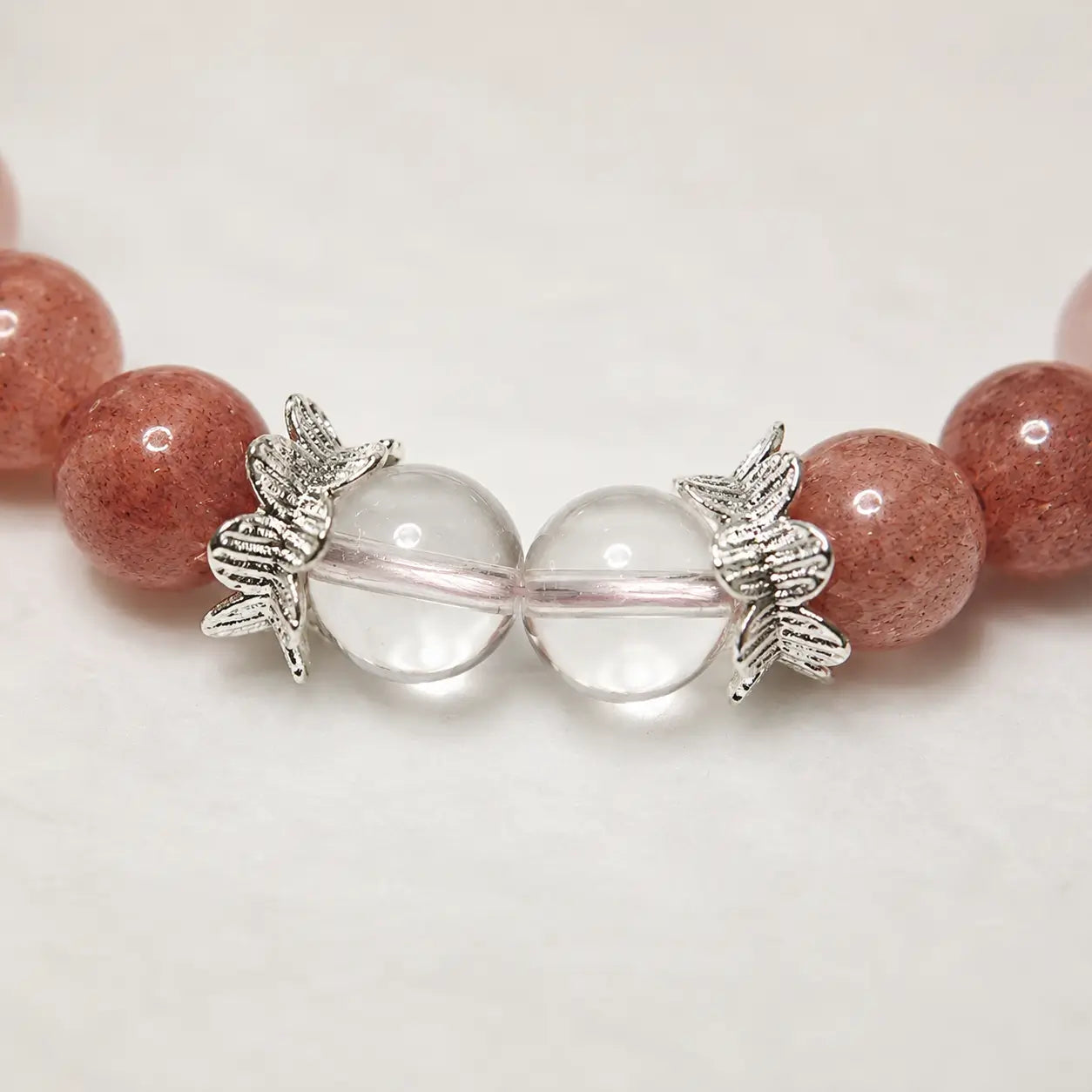 AURA Amulet close-up of handmade best friend bracelets with silver leaf beads and clear quartz.