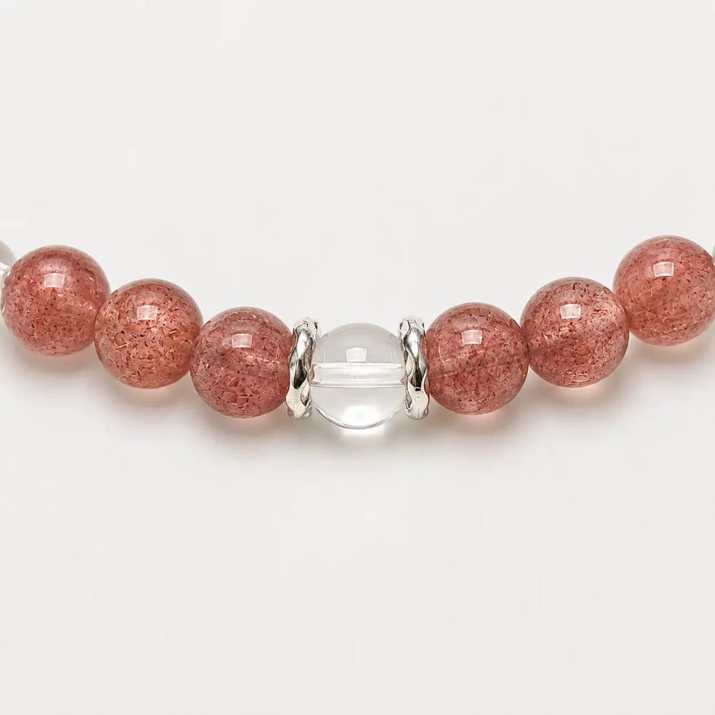 AURA Amulet macro detail of strawberry bracelet and clear quartz with silver accessories, a handmade charm bracelet.