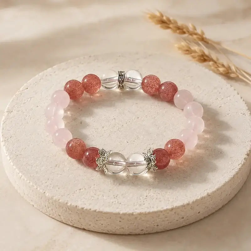 AURA Amulet Strawberry crystal and rose quartz bracelets on stone with wheat, natural healing crystal jewelry.
